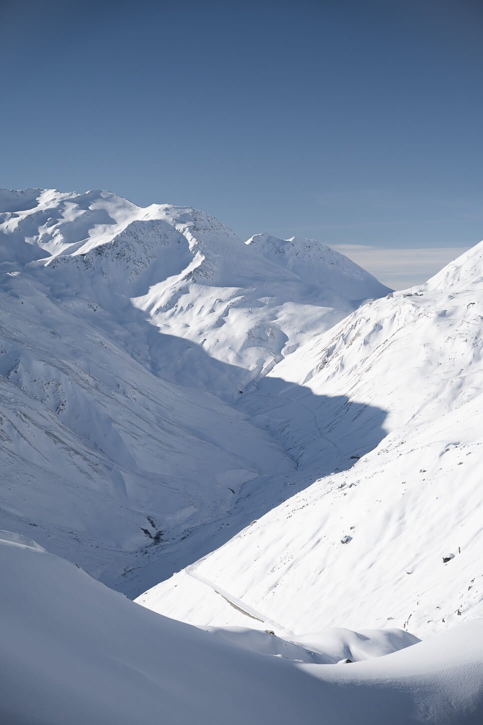 Mountain shadows against the backdrop of snow-capped peaks.