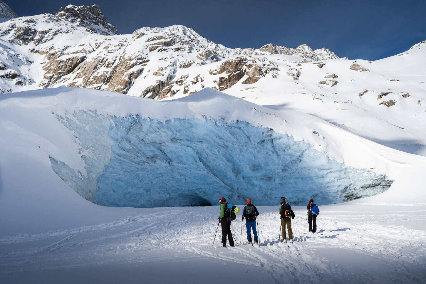 cross-country skiers watchingh a glacier.
