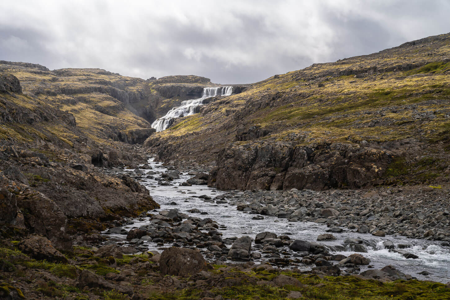View of a hidden waterfall in the west fjord from a distance.