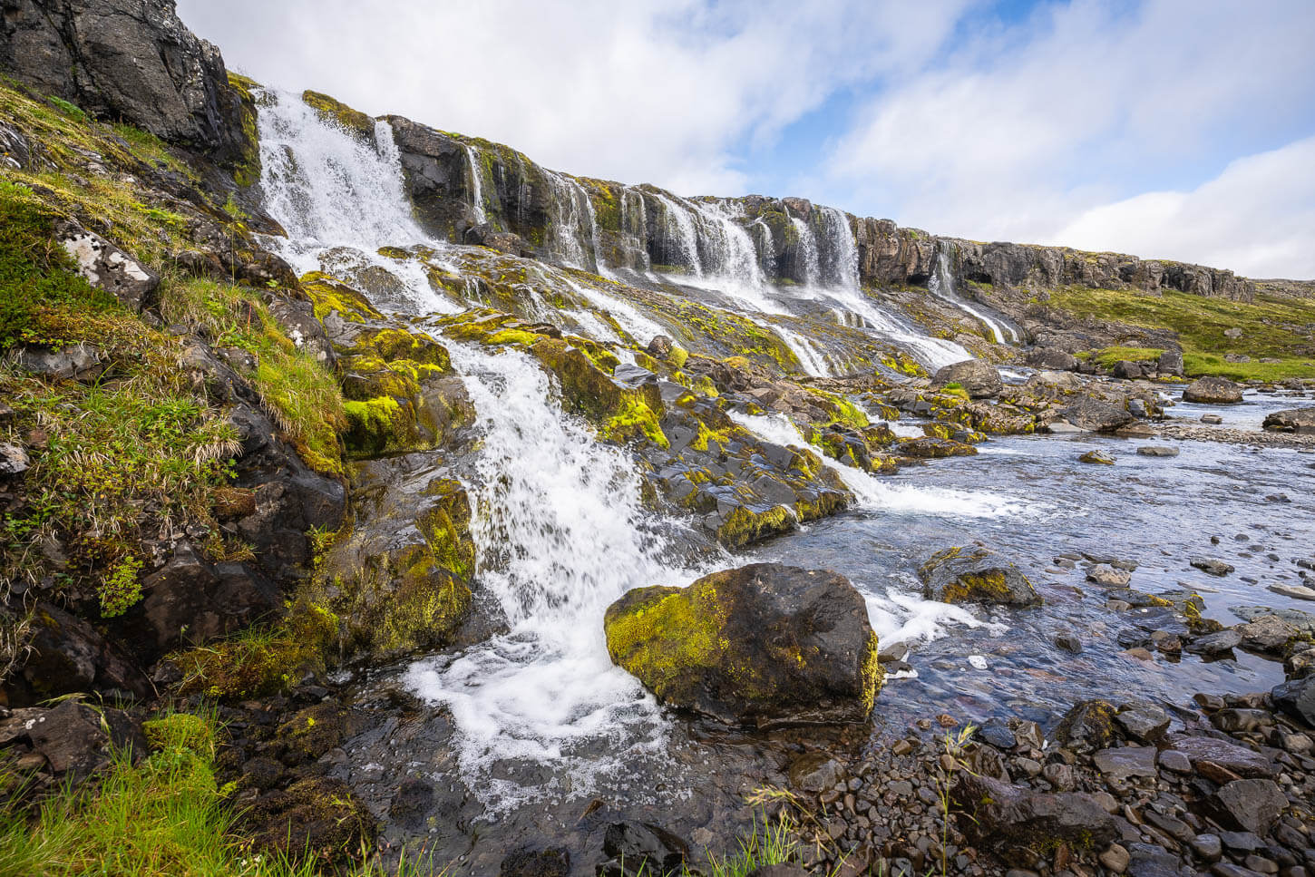 Húsárfoss, a unique waterfall in the remote westfjords, with miltiple streams along a mossy rockface.