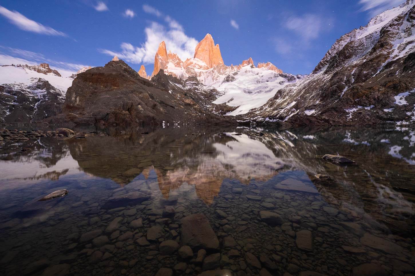 Laguna de los tres viewpoint at the end of the Hike, with the Fitz Roy catching the first light of the day, reflecting in the waters of the Laguna.