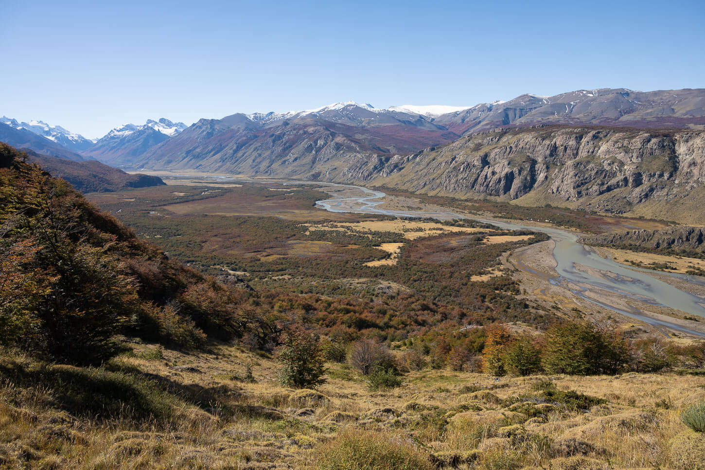 Meandering river in Patagonia under a blue sky.