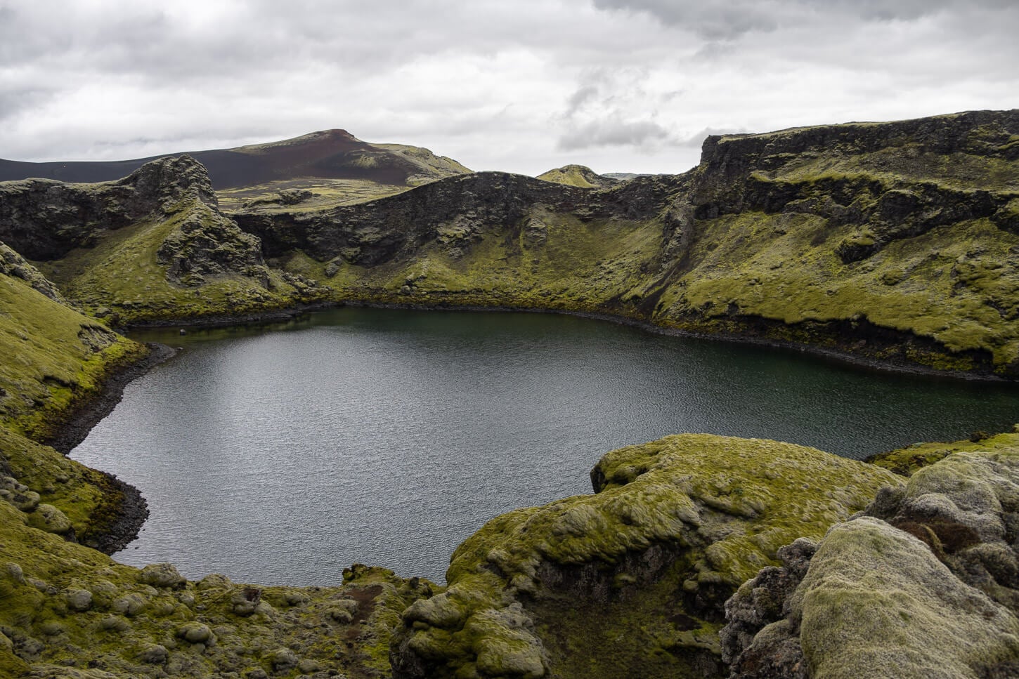 Tjarnargígur Crater with its small lake inside it.