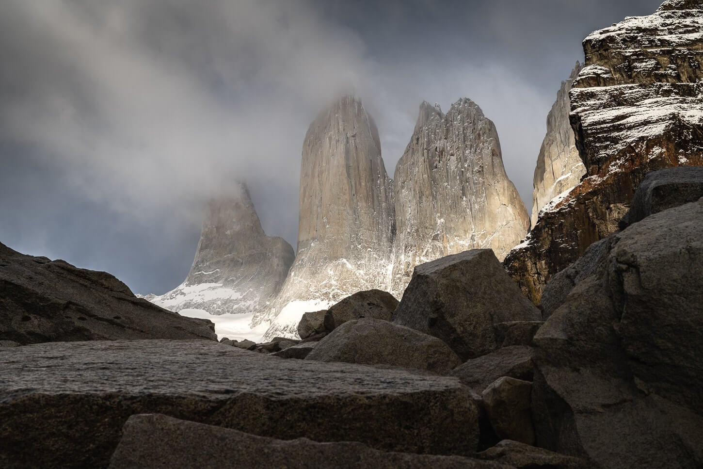 Dramatic views of the Torres lit by the light but also partly covere din clouds.