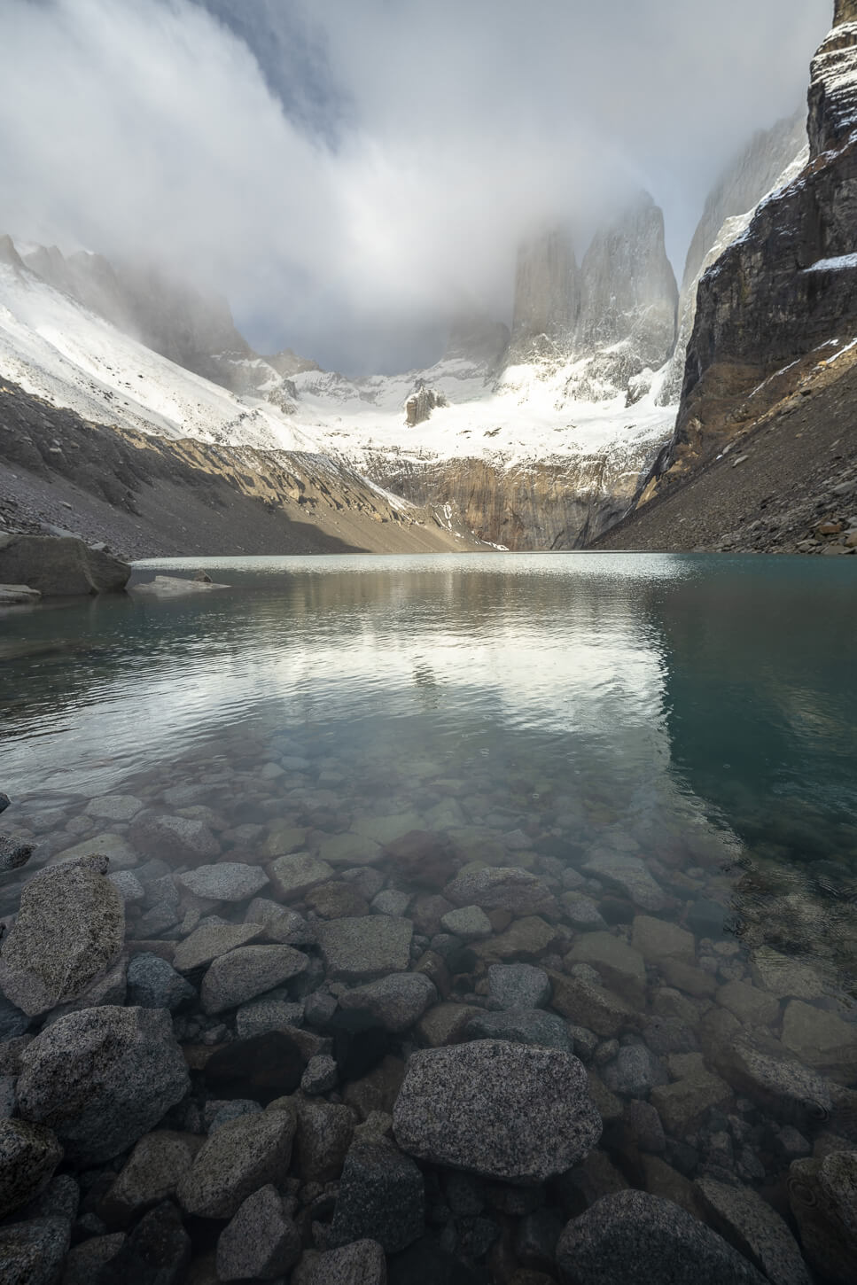 Portrait orientation image of the Base Torres viewpoint with underwater rocks in the foreground