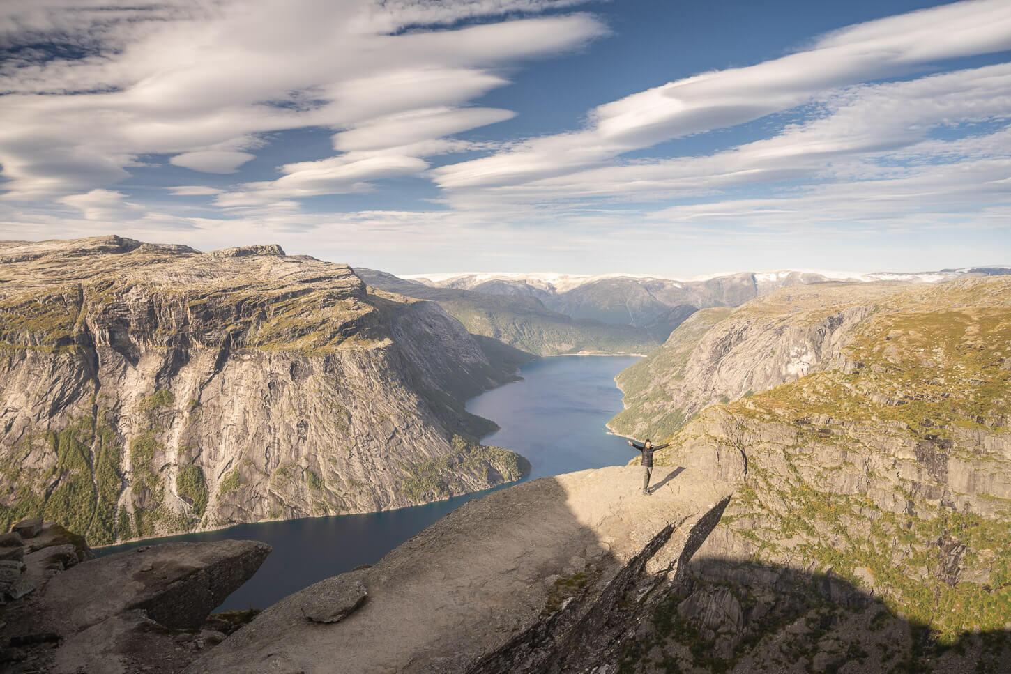 Hiker standing on Trolltunga, happy to be there.