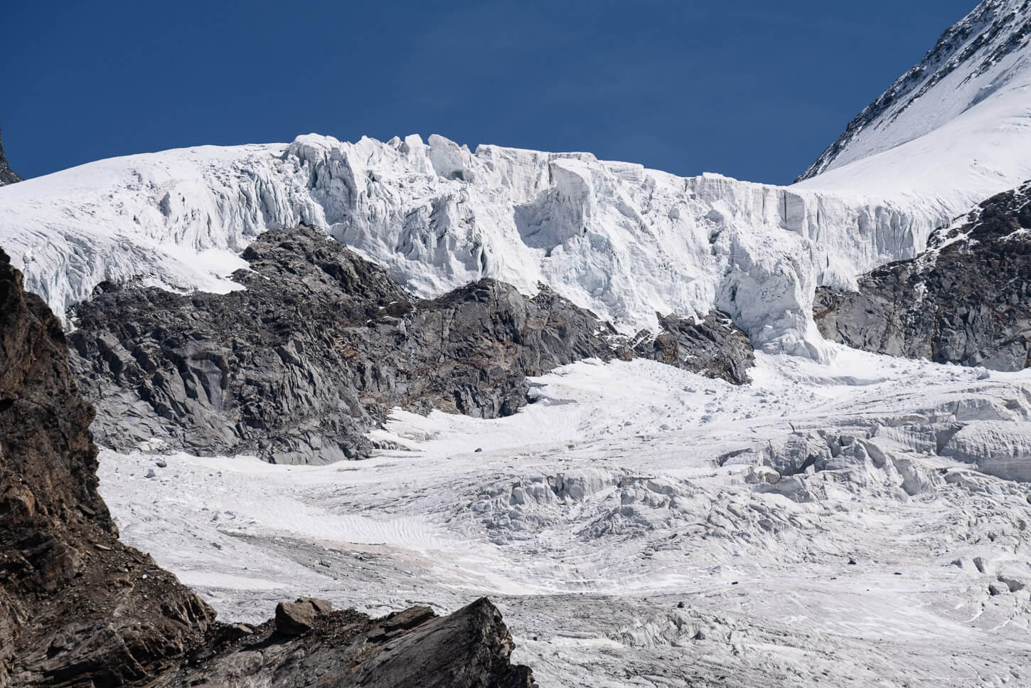 Massive glacier front under a deep blue skyy.