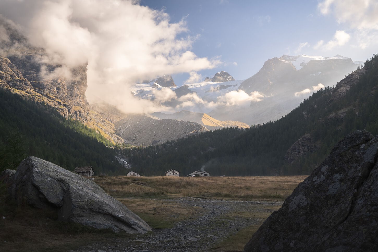 Piani di Verra inferiore with an epic view of the glaciers between the clouds in the early morning light in the background