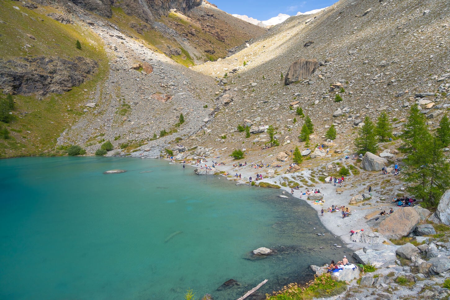 Lago Blu in Val d'Ayas in Summer, with many people enjoying the day on the shores of the lake.