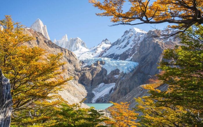Mirador piedras Blancas Viewpoint at the end of the hike, with the hanging glacier in the distance, framed by the vibrant coloros of lenga trees in Autumn
