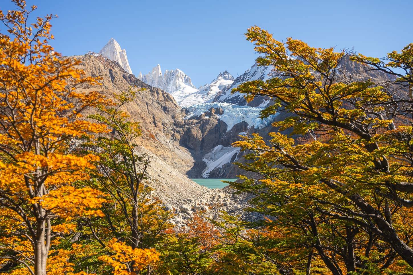 Colorful trees framing the panoramic view from Mirador Piedras Blancas on a bright sunny day with bloudless blue sky.