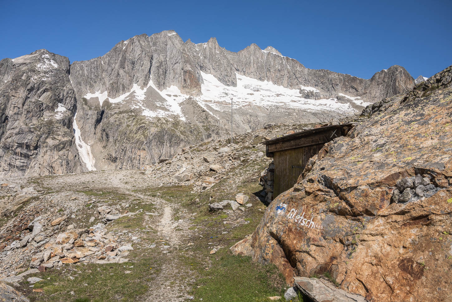 Sign pinted on a rock pointing to the trail descending to the oberaltsch glacier.