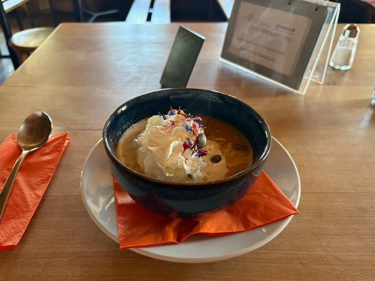 Carrot soup with whipped cream on a table served inside the Oberaletsch hut.