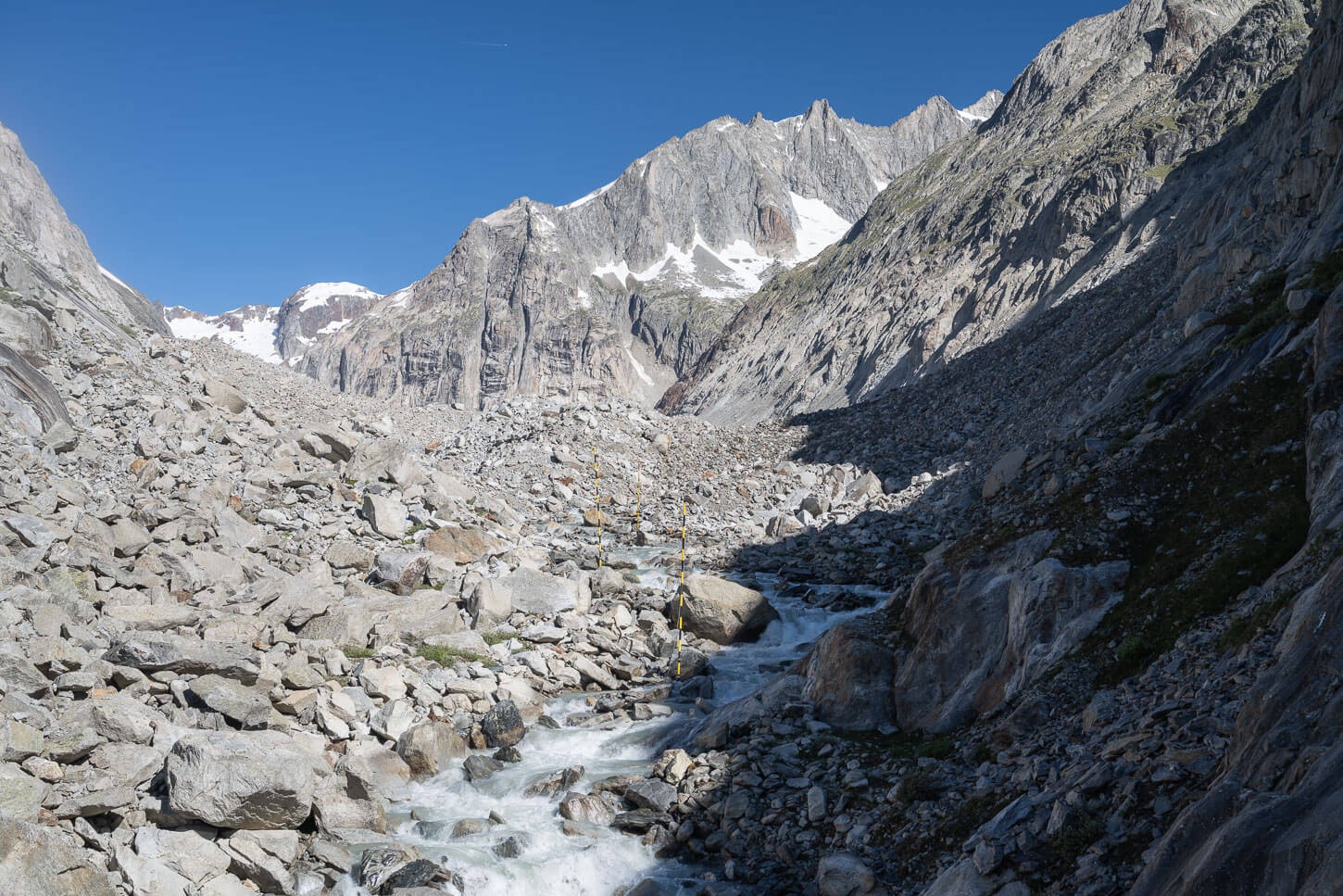 Glaxiar river from the Oberaletsch glacier, treaming throgh boulders that feel from the mountainside.