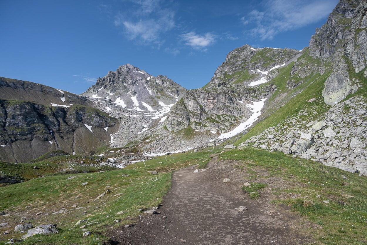 Hiking trail to Wildsee in early summer, with patches of snow on the mountainside.