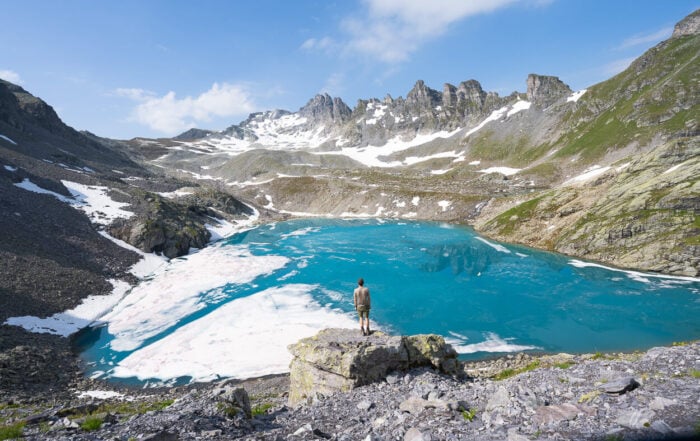 Hiker standing on a rock in front of Wildsee, the most popular lake on the Pizol Five Lakes Hike