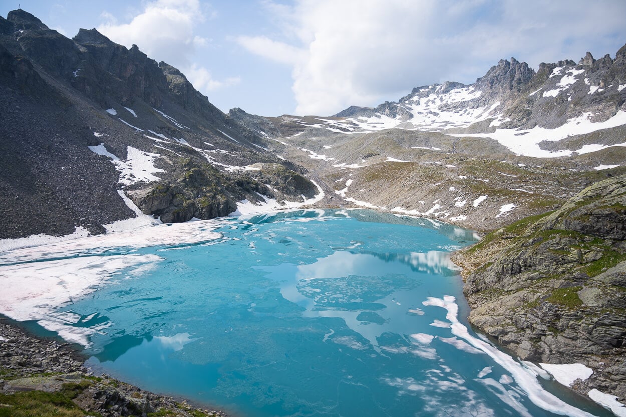 Wildsee in June, still partly covered in ice but with the Sun highlighting its beautiful turquoise color.