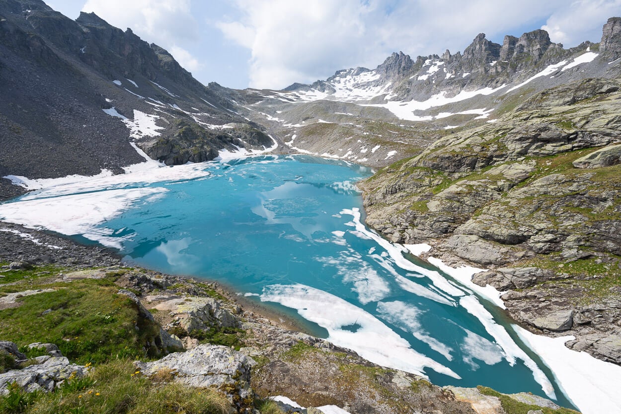 WIldsee partlly covered in ice, with Pizol's summit in the background