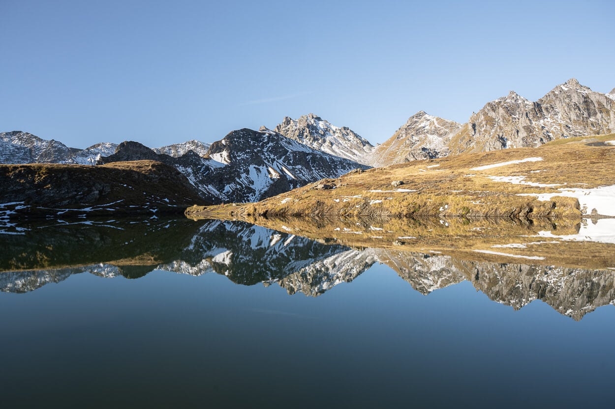 Wangsersee in autumn, under a clear blue sky.