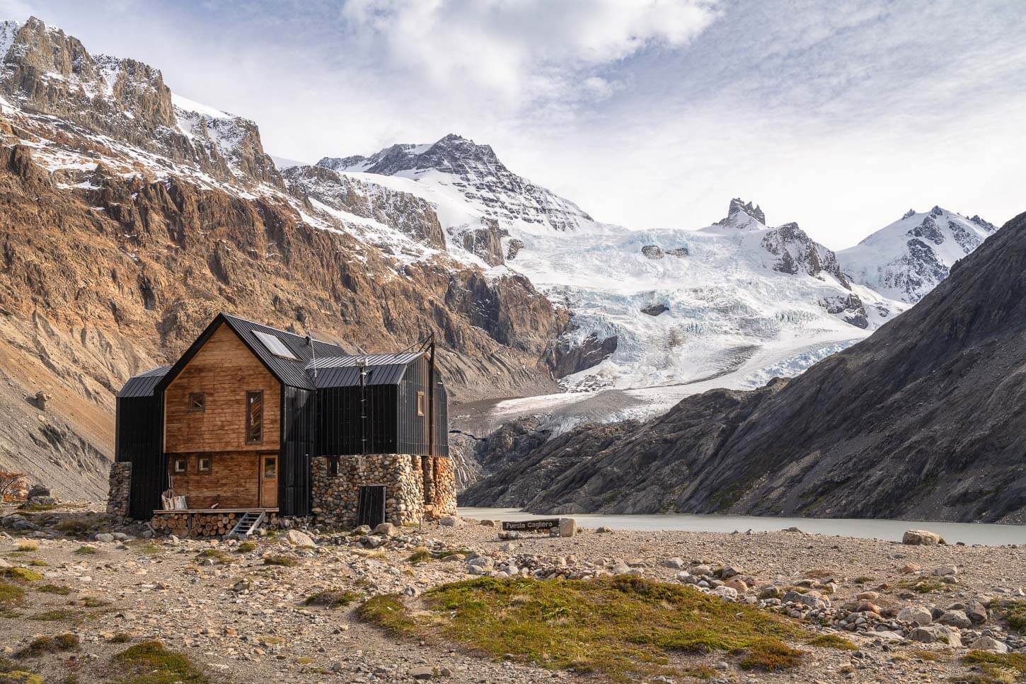 Puesto Cagliero, the end point of the Hike to the Outpost, with the view of the hut and the glacier in the background on a sunny day with vibrant autumn colors.