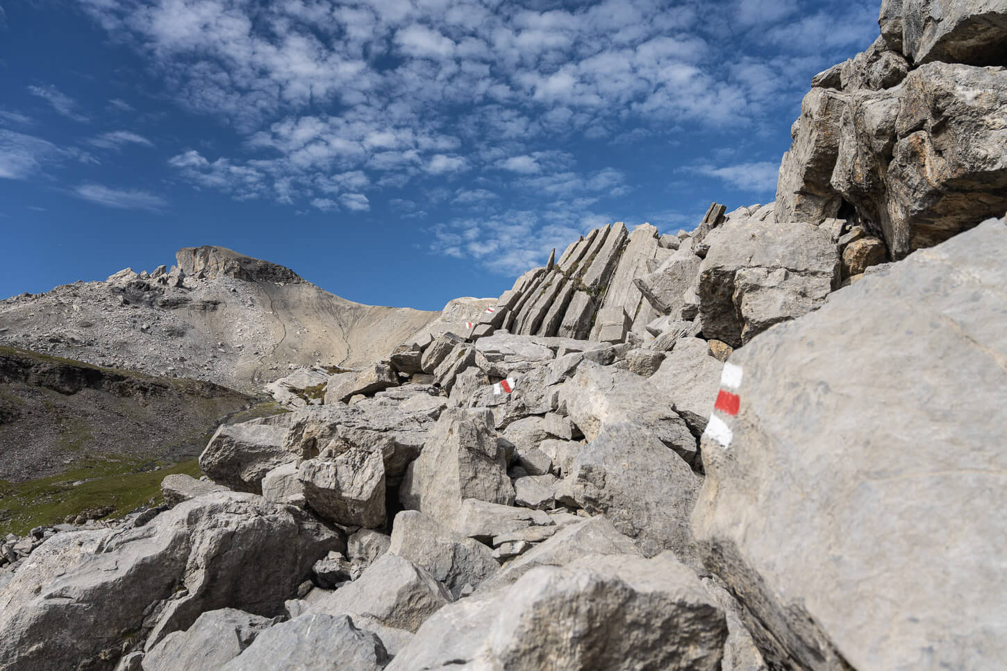 Mountain hiking trail across a boulder fields with clearly marked, painted trail marks.
