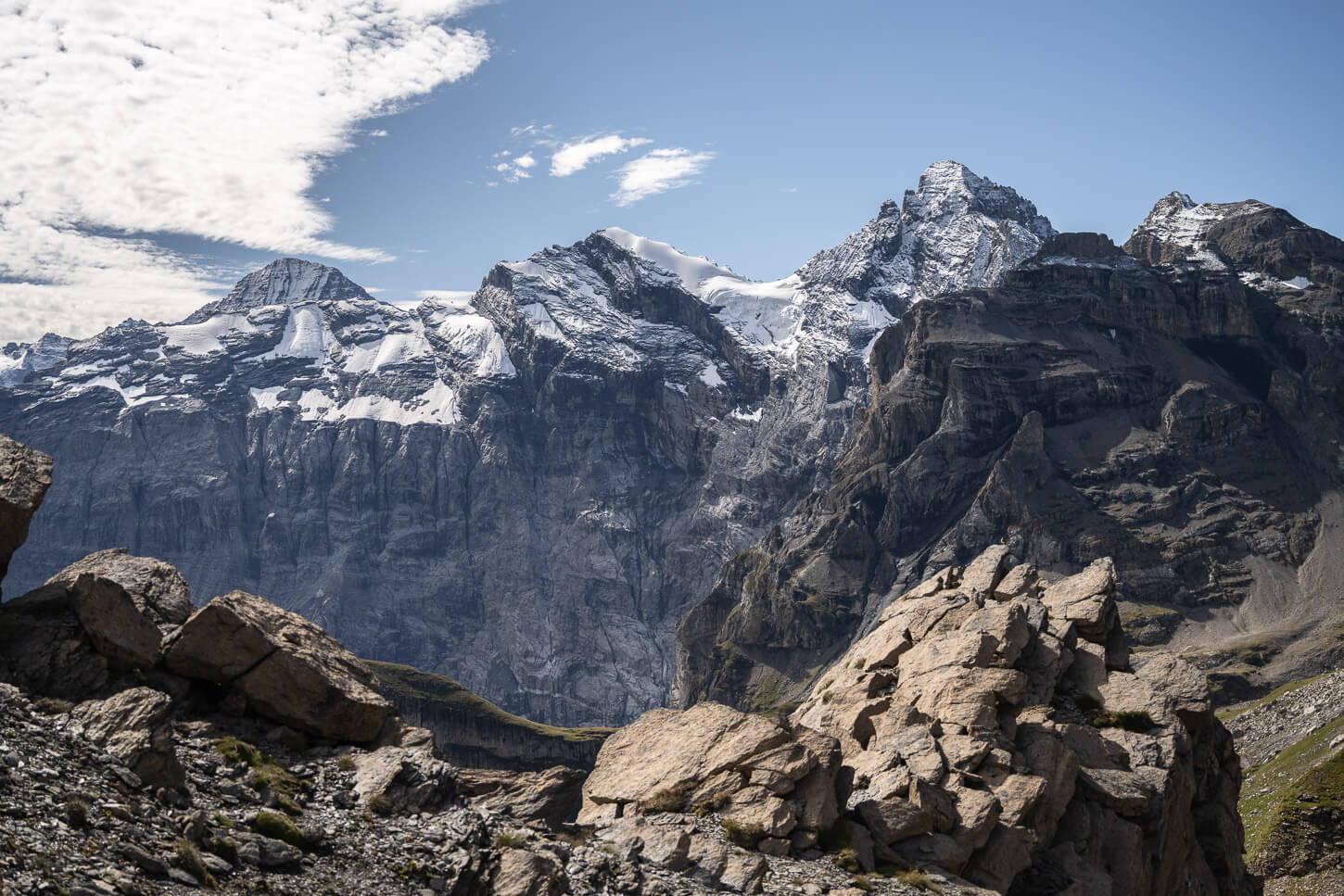 Mountain Landscape with sheer rock faces covered in glaciers, in the distance.