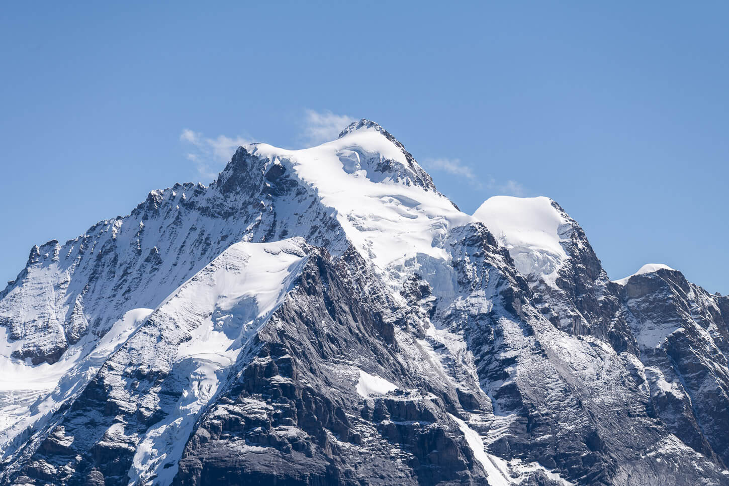 Detail of the Jungfrau's summit and its glacier, against a clear blue sky.