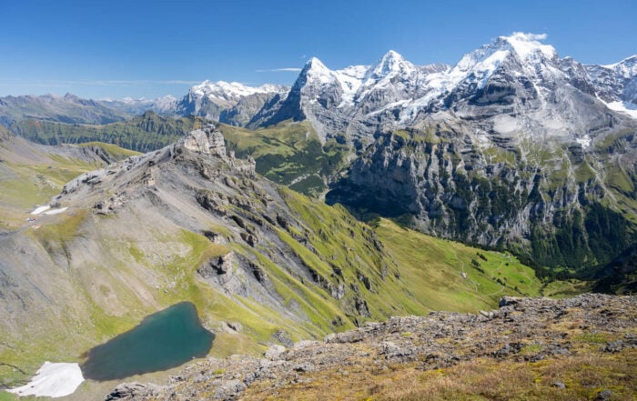 Epic Landscape photo from a Hike to Schiltorn with the green Lauterbrunnen Valley below the towering peaks of the Eiger, the Mönch, and the Jungfrau.