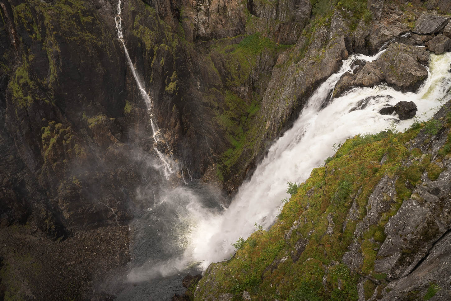 Viewpoint of the Vøringsfossen waterfall almost directly above the falls, with a vertical view of the water crashing 163 meters into the valley below.
