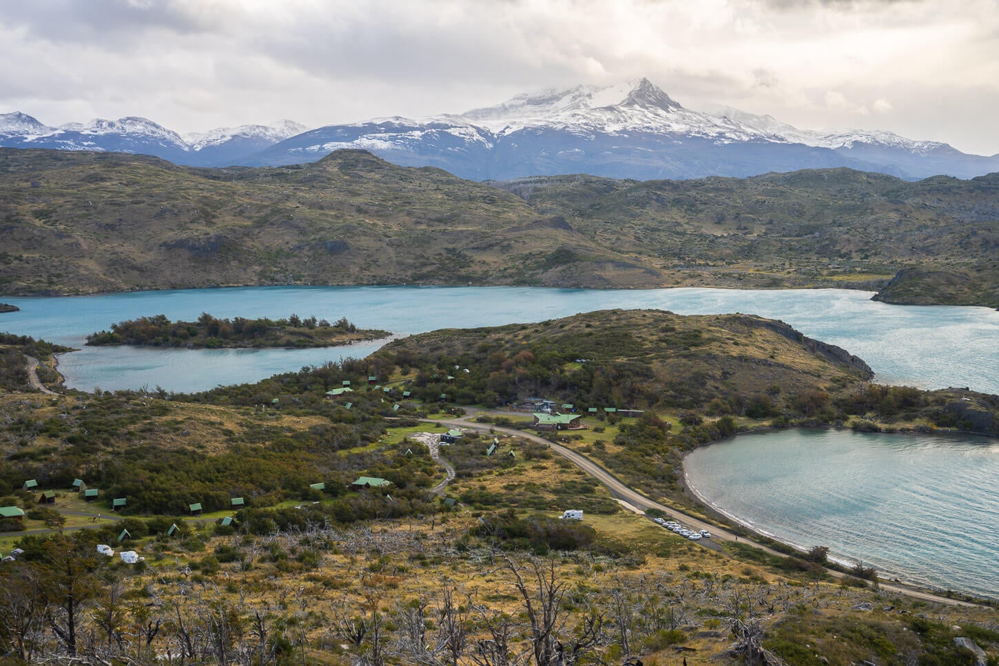 View of Camping Pehoé and the road with a small parking area that is the other trailhead for Mirador Condor.