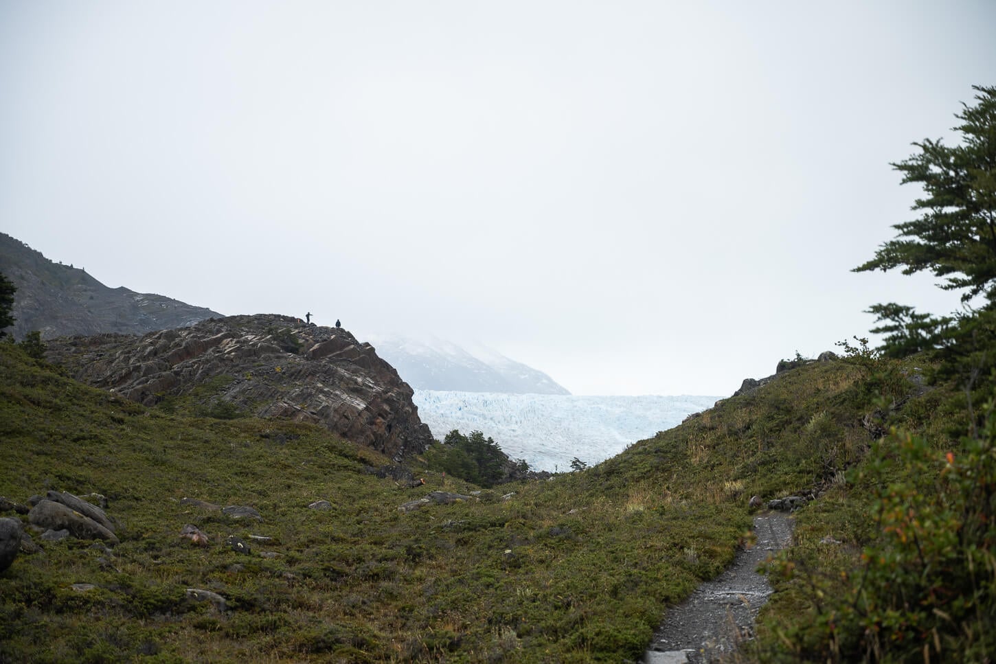 View of mirador Glacier Grey with two hikers standing on it
