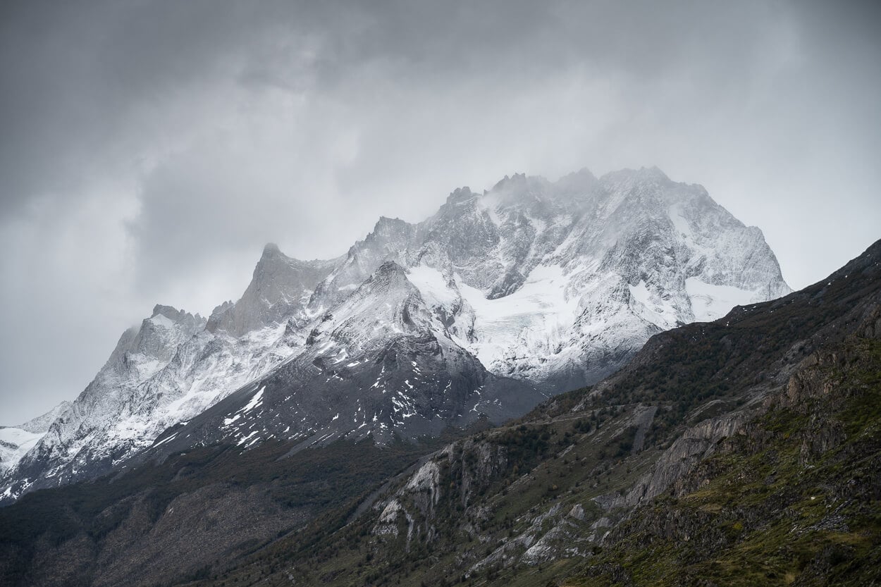 Jagged peaks of the Paine Grande massif are partly covered in snow, as viewed from the hiking trail to Mirador Glaciar Grey
