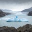 Mirador Glacier Grey lookout on a cloudy day, with an iceberg floating in a lagoon in front of Glacier Gray, under a moody sky,
