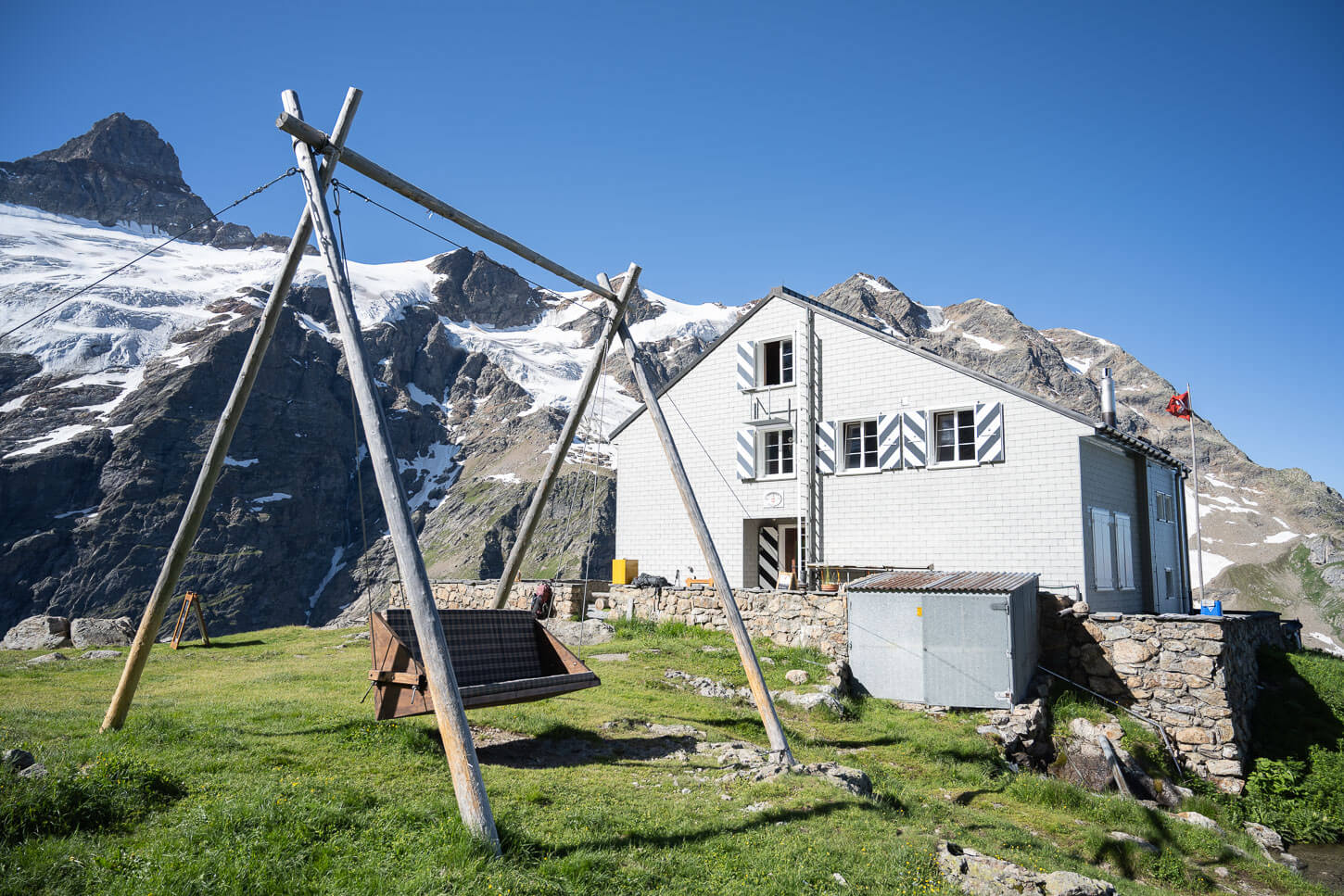Glecksteinhütte and its swing, with the glacier in the background.