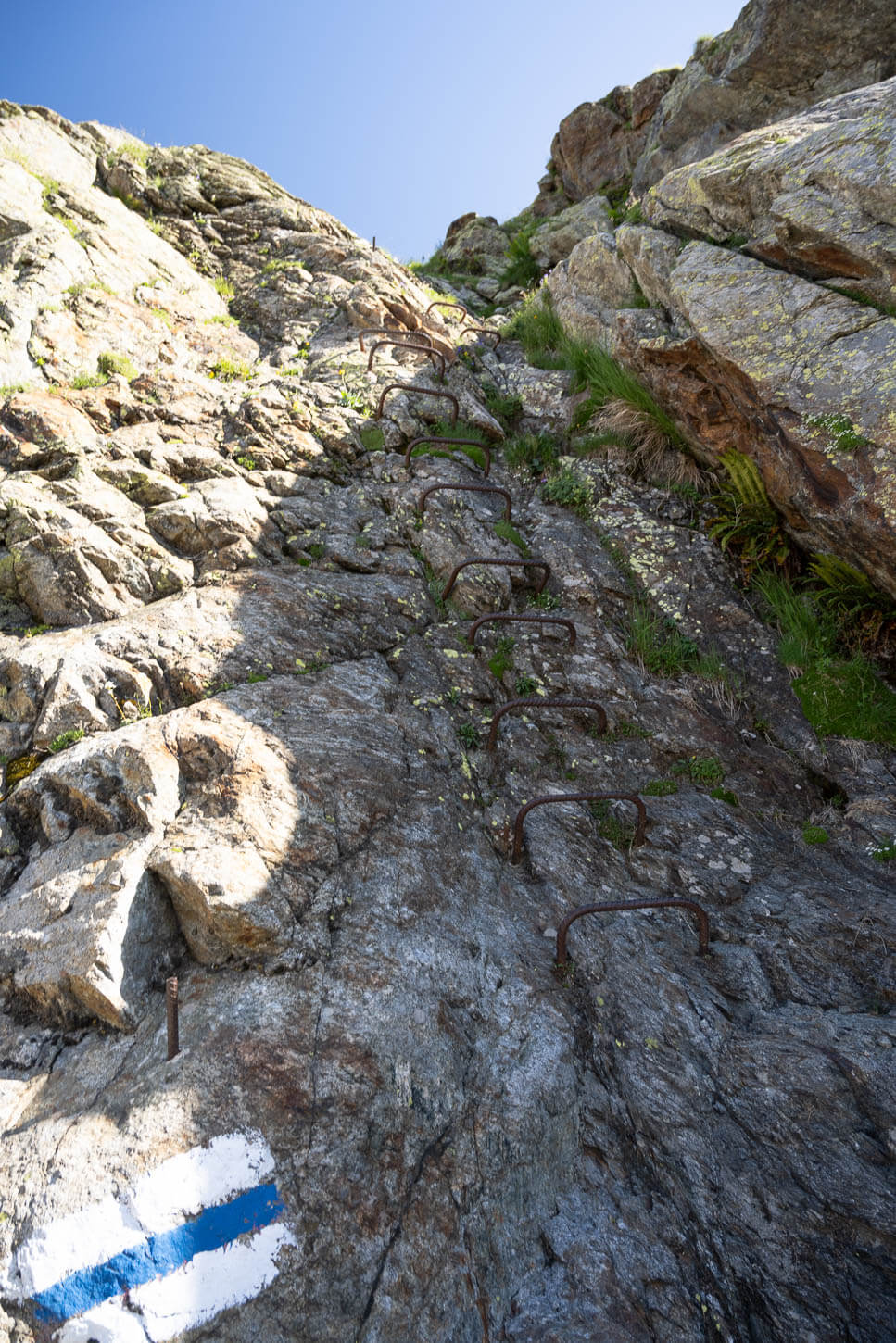 Section of the Beesbärgli trail with steps bolted ont a vetical rock face.