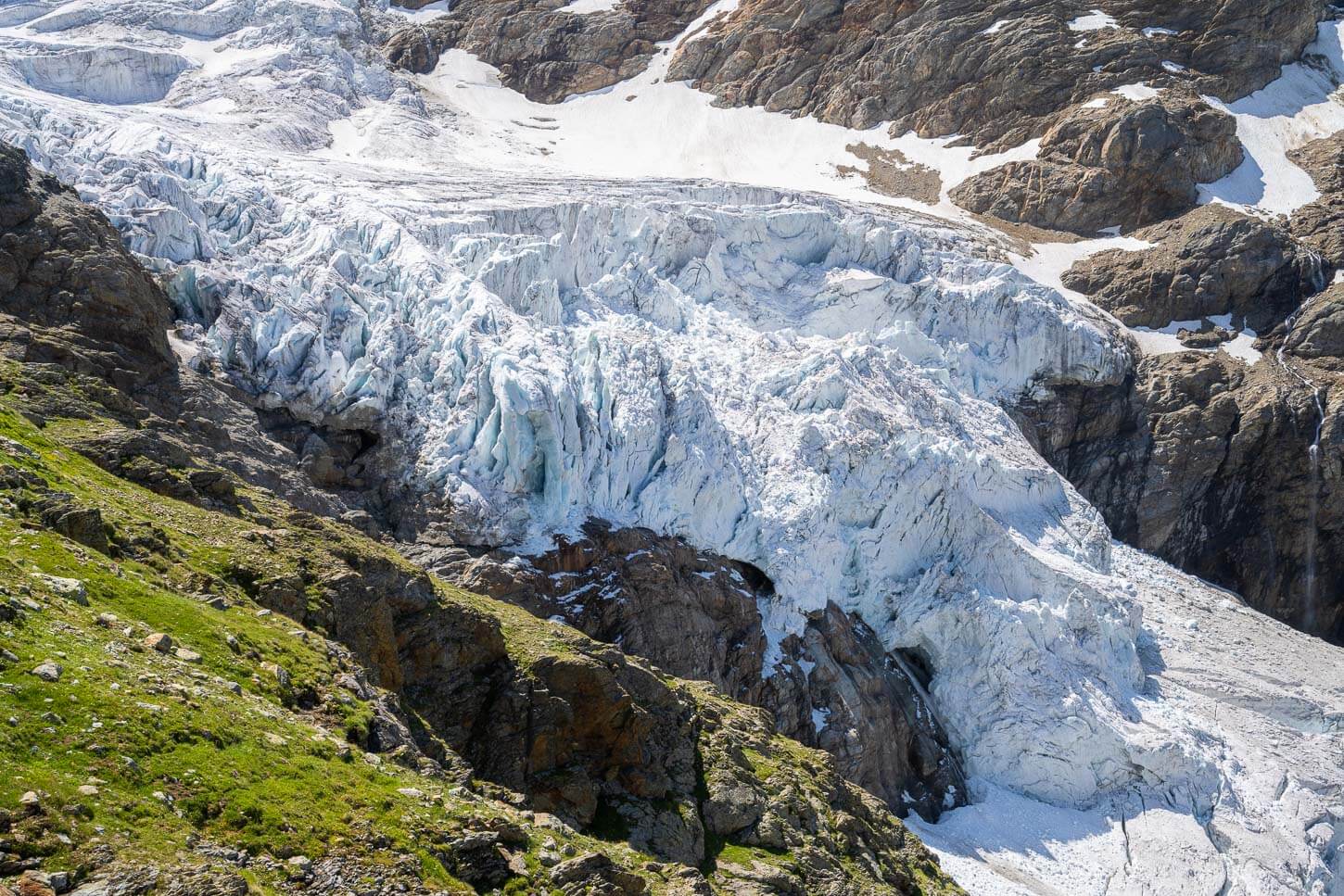 Upper Grindelwald Glacier's tongue with several crevasses visible from a hiking trail nearby