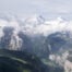 Panoramic View from the Wengen to Männlichen loop hike with open views of the green lauterbrunen valley un a sunny but partly cloudy day.