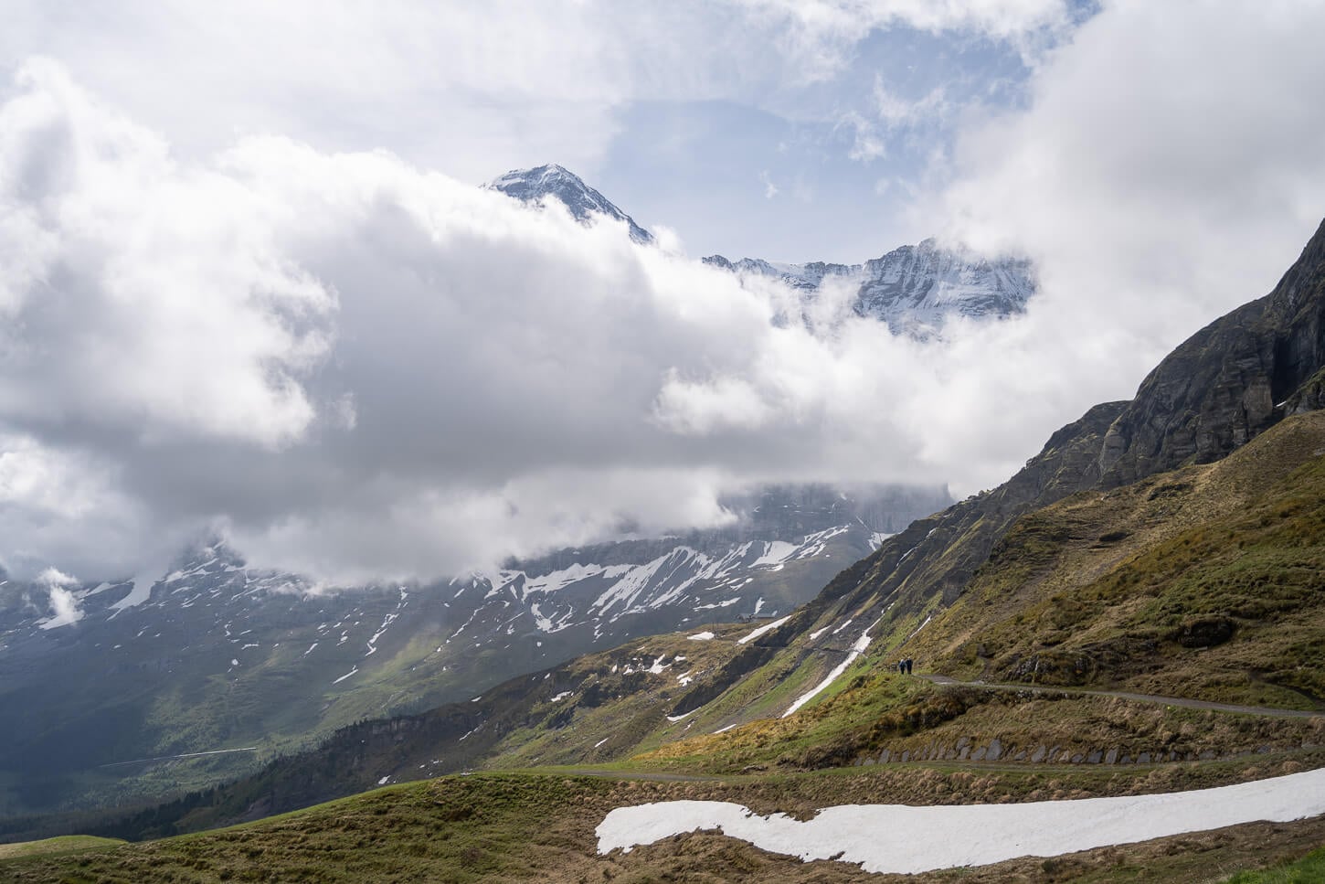 Panorama trail part of the hike from Männlichen to Lauberhorn, with low clouds oartly covering the landscape.