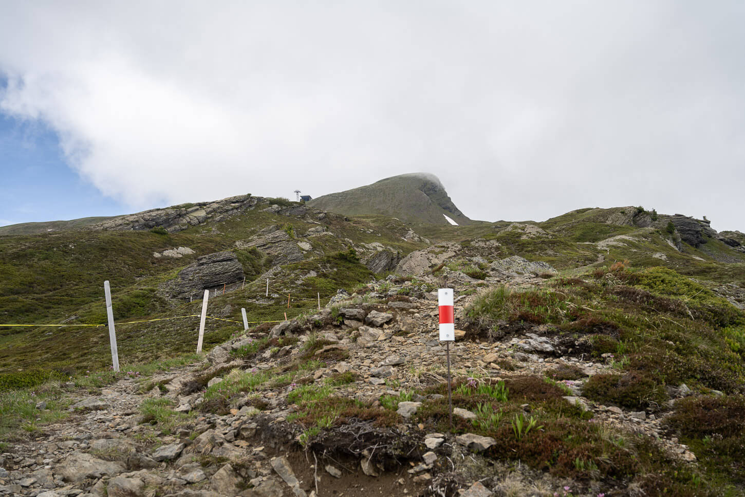 Marked trail where the hike to the Lauberhorn starts, with the summit in view farther uphill.