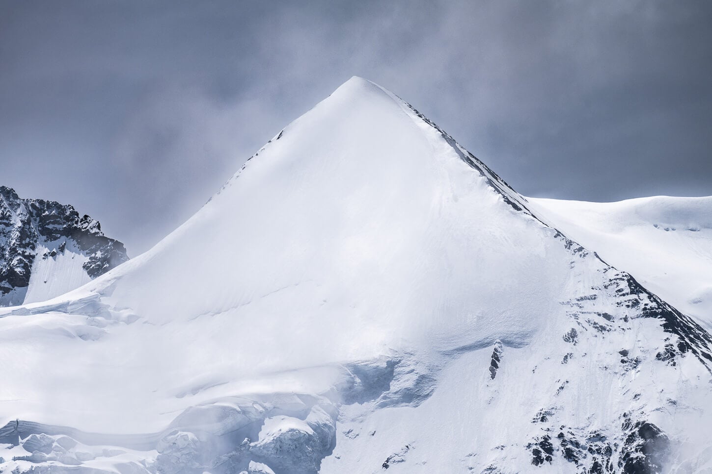 The beautiful pyramidal shape of the Silberhorn, a peak in the Jungfrau massive covered in snow that looks like a pyramid.