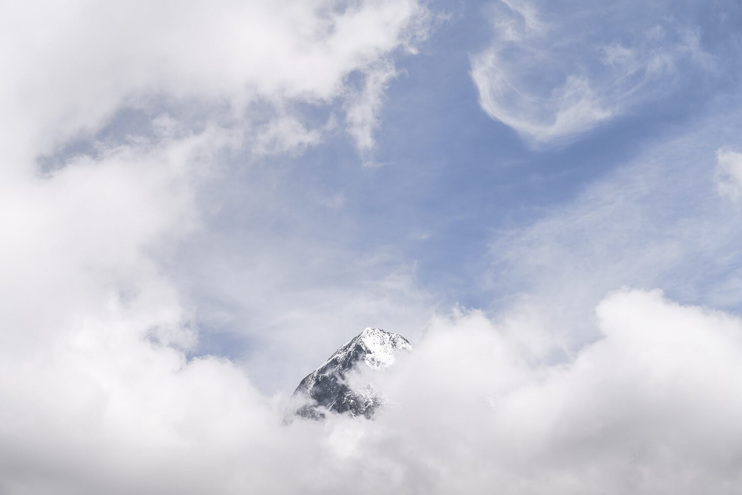 Mountain Peak partly visible through the clouds and under a blue sky.