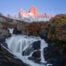 View of El Chaltén's Hidden Waterfall, which makes for a spectacular sunrise hike in Patagonia, with the warm light of the rising sun hitting Mount Fitz Roy, above the hidden waterfall.