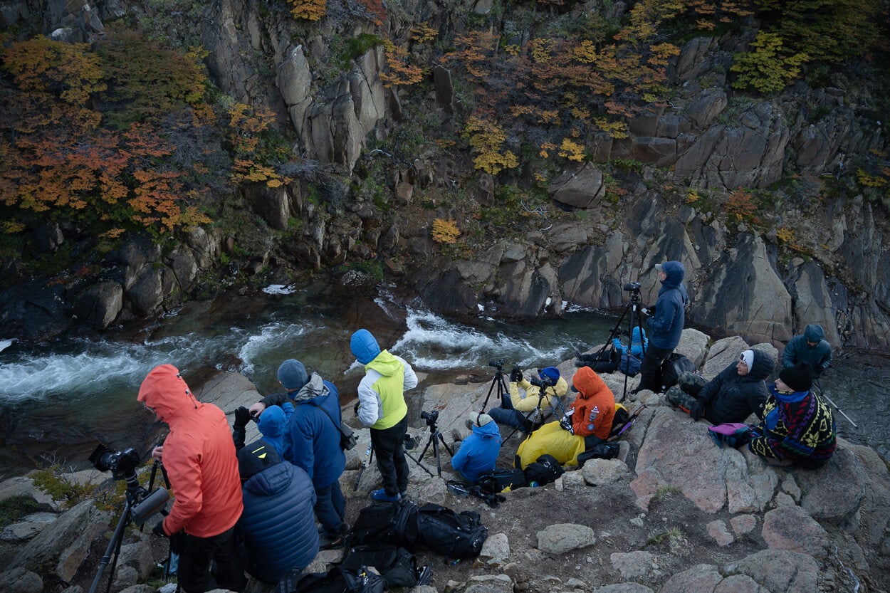 Main viewpoint of the Secret Waterfall in Patagonia, with photographers and their tripods standing on it.