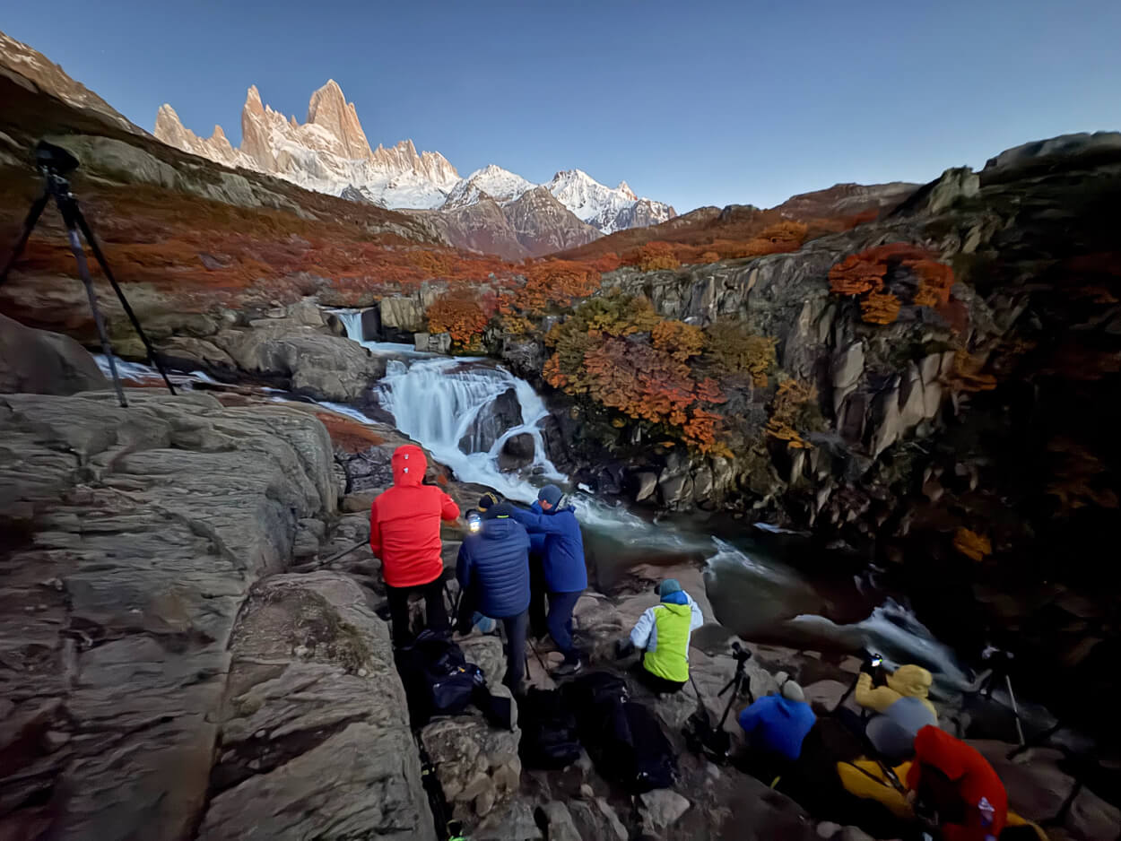 Photographers lined up in front of the hidden waterfall, or cascada escondida, in Patagonia near El Chaltén, ready to take a photo for sunrise
