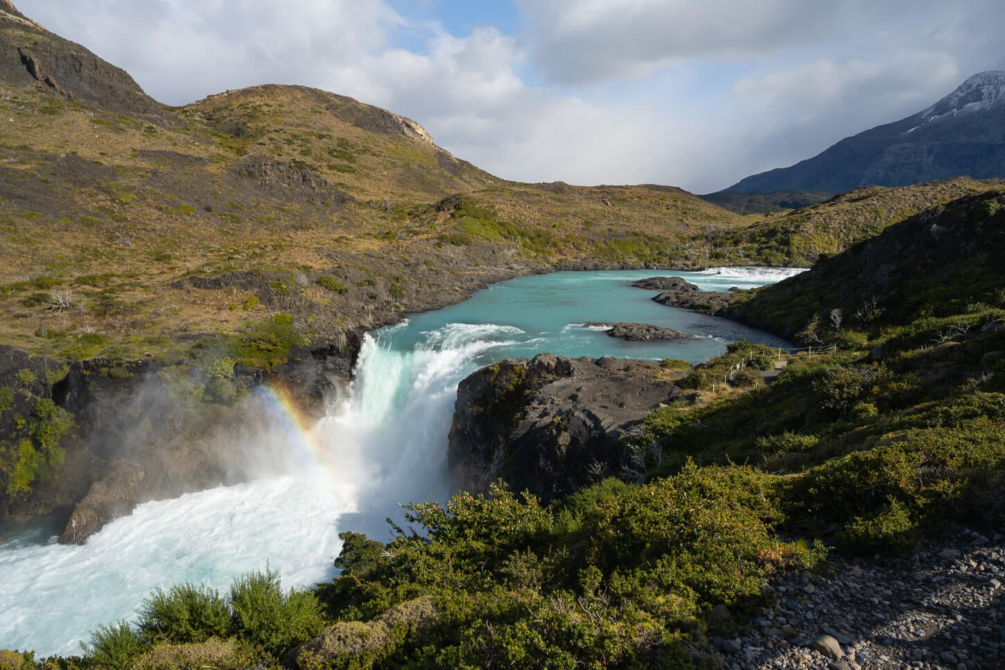 View of the Salto Grande Waterfall from Mirador Salto Grande, on a sunny day, with a rainbove in the water vapor