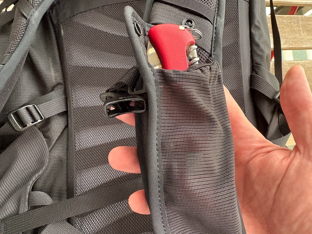 Osprey Talon's mesh pocket on the strap, showing the size with a swiss knife inside.