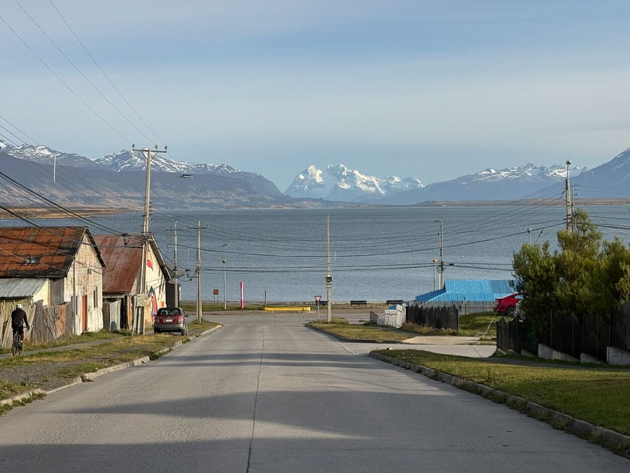 View of the landscape around Puerto Natales from a road in town, with glaciers. and mountains in the distance.