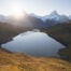 Bachalpsee at sunrise with the sun peaking above the mountains and flooding the landscape with light