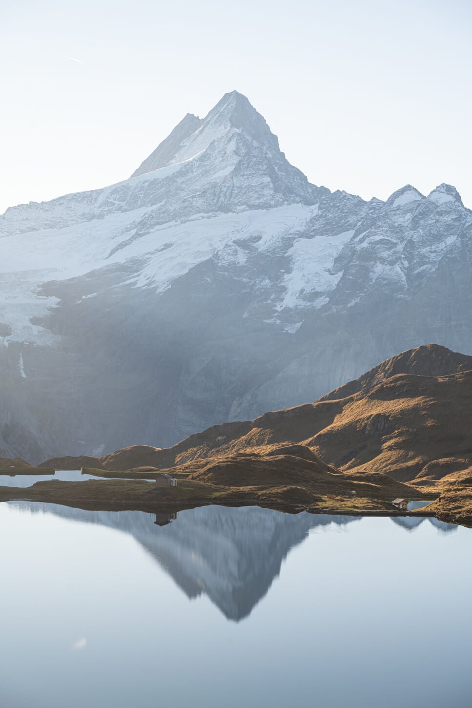 view of the imressive schreckhorn partly covered in snow, reflectd in a lake