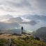 View from Himmeltinden in the Lofoten, with a hiker looking at the landscape diring the hike